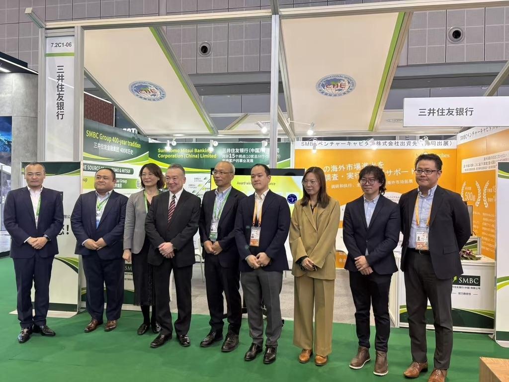 Commemorative photo at the booth featuring H.E. Ambassador Okada, Consul General of Japan in Shanghai (fourth from left), SMBC China President Yokohata (standing to the Ambassador’s right), and Arches Shanghai Director Miyazaki (standing to President Yokohata’s right).